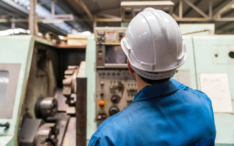 Technicians work at industrial machines in large factories.