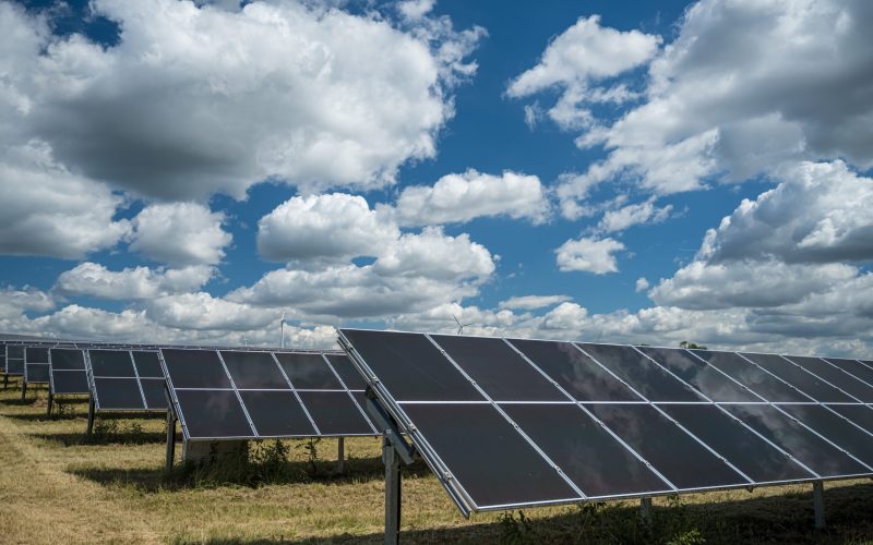 The solar panels used for renewable energy on the field under the sky full of clouds